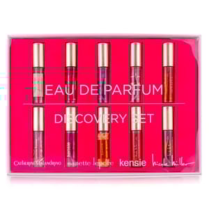 A set of six small cylindrical Eau de Parfum bottles by various designers displayed in pink packaging.