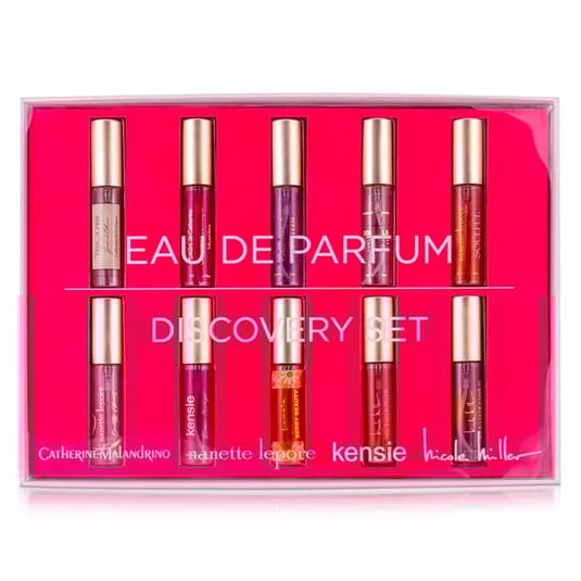 A set of six small cylindrical Eau de Parfum bottles by various designers displayed in pink packaging.