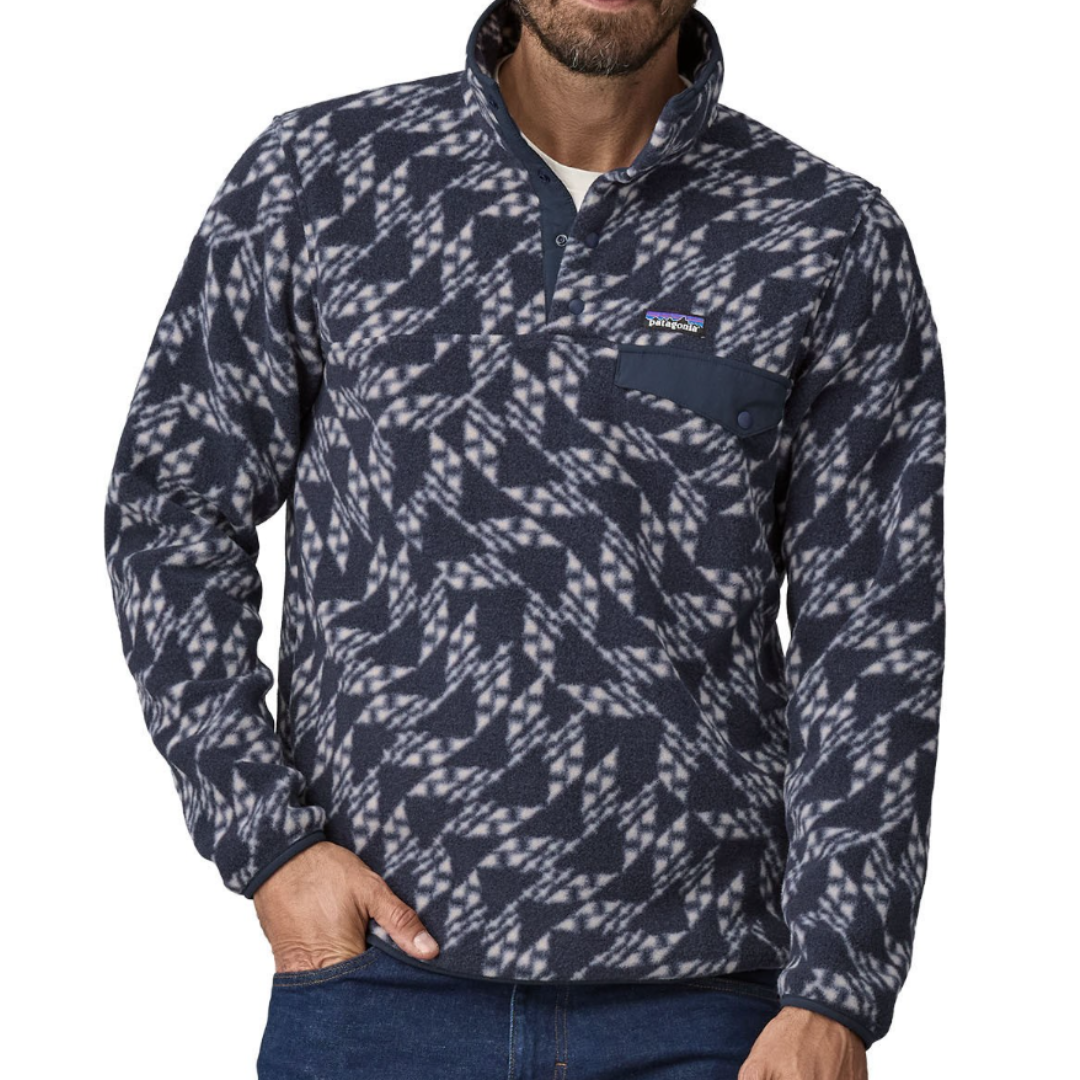 A man wears a patterned Patagonia fleece pullover with a navy geometric design, featuring a snap closure and pocket on the chest.