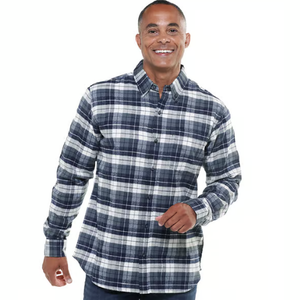 A man wears a blue and white plaid flannel shirt, featuring long sleeves and a button-up front.