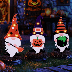 Three Halloween-themed gnome decorations are displayed, each with a distinct hat design and holding items like a broom, a jack-o'-lantern, and a cauldron, all illuminated with small lights.