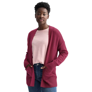 A person is wearing a red open-front cardigan over a light pink T-shirt, paired with blue jeans.
