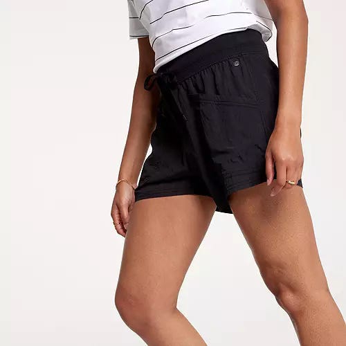 Black crinkle patch shorts with a drawstring waist and a 4-inch inseam, designed for women. The shorts feature a white striped shirt tucked into them.