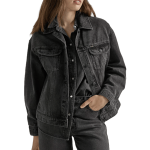 A person wearing a black denim jacket over a dark button-up shirt and jeans, featuring a relaxed fit and classic design with chest flap pockets and button closures.