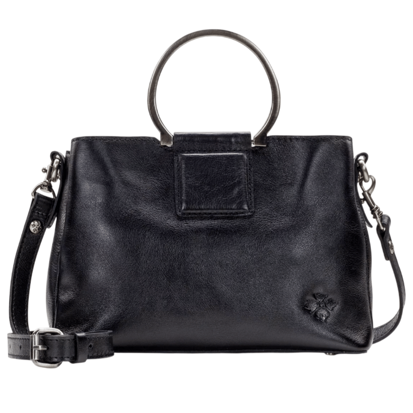A black leather handbag with circular metal handles and a detachable shoulder strap, featuring a small embossed floral detail.
