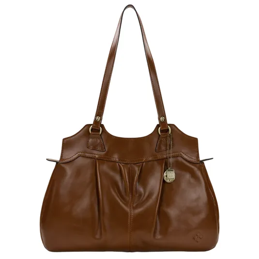 A brown leather handbag with double handles and a decorative metal charm. The design features pleats on the front and a small embossed logo in the corner.