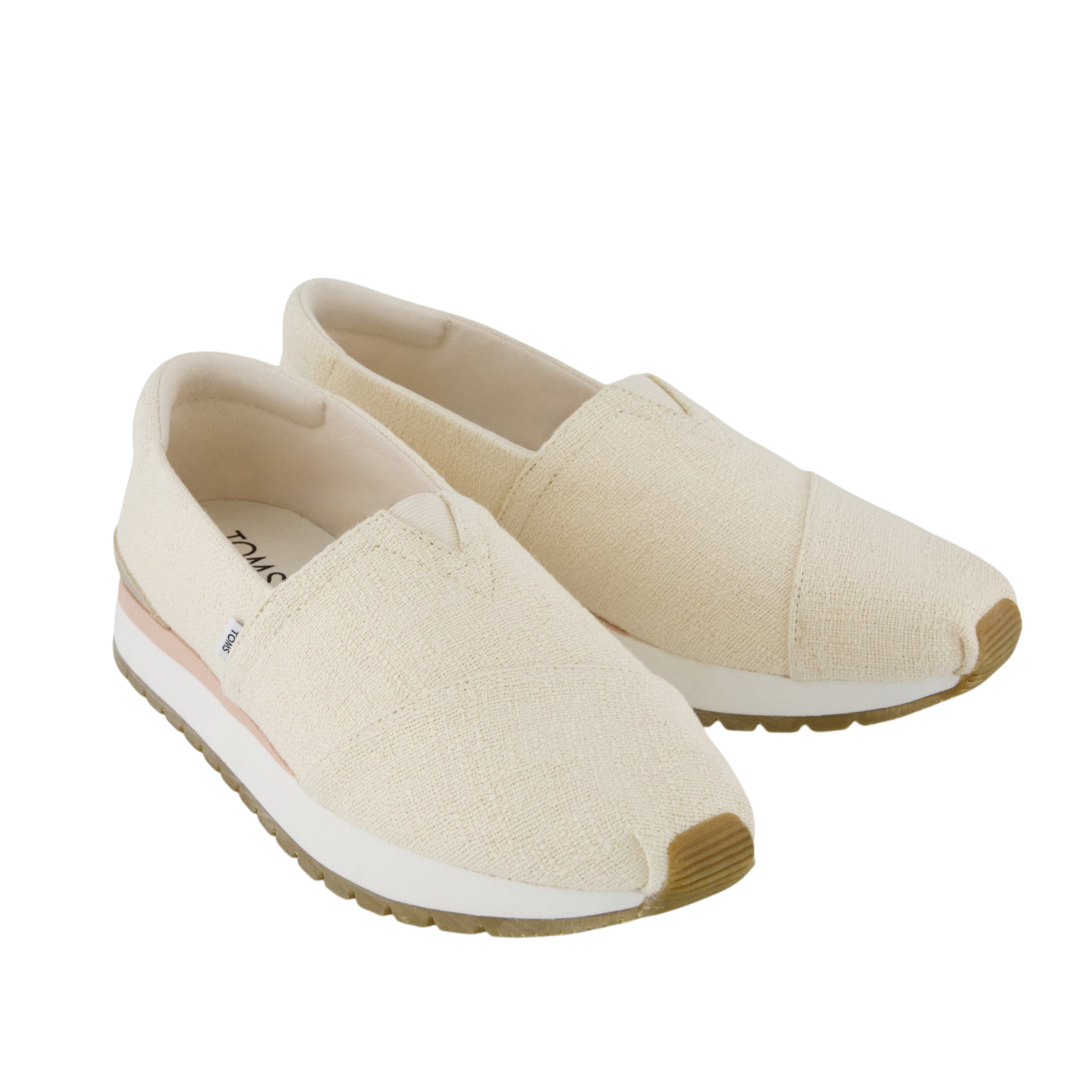 A pair of cream-colored slip-on shoes with a textured fabric upper, brown sole accents, and a thick white sole.