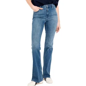 A person wearing high-waisted blue bell-bottom jeans with a slightly faded wash and a black top, paired with white sneakers.