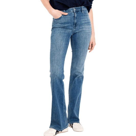 A person wearing high-waisted blue bell-bottom jeans with a slightly faded wash and a black top, paired with white sneakers.