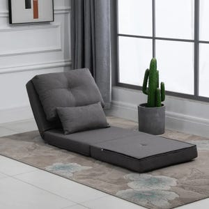 A gray adjustable floor chair with a matching pillow, next to a potted cactus.