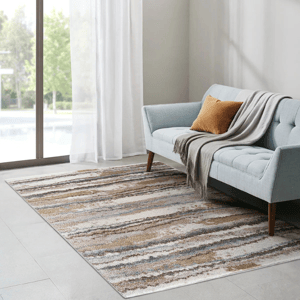A living room setup with a light blue tufted sofa, a brown pillow, and a gray throw blanket. A textured area rug in neutral tones and large windows with sheer curtains complete the minimalist decor.