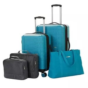 A set of teal-colored luggage consisting of two roller suitcases, a carry-on bag, a duffle bag, and a tote bag, all varying in size.