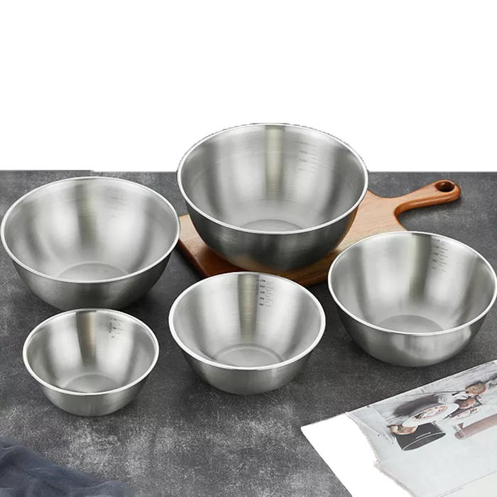 Set of 5 stainless steel nesting bowls of varying sizes, ideal for mixing or serving. They feature brushed metal finishes and some have measurement markings inside, shown on a table with a wooden board underneath the largest bowl.