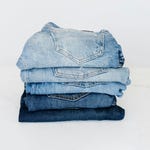 A stack of various shades of blue denim jeans folded neatly.