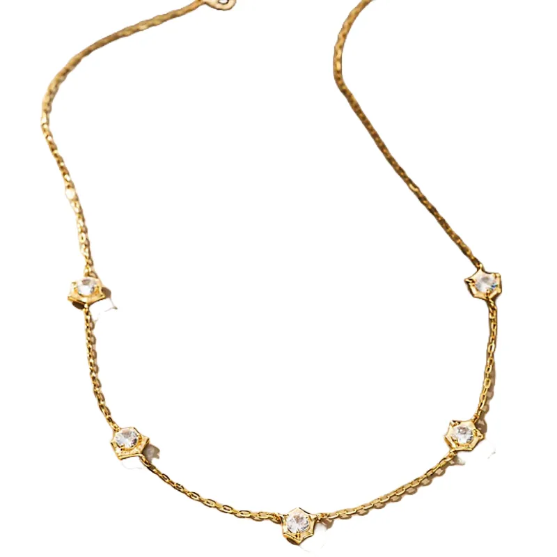 A gold chain necklace featuring five evenly spaced, star-shaped crystal studs. The delicate design combines simplicity with a touch of sparkle.