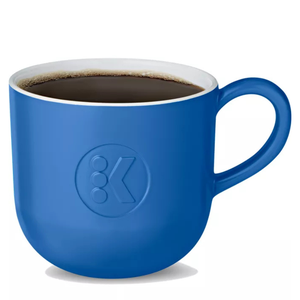 Blue mug with a K logo, filled with coffee.