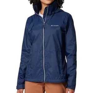 A person is wearing a dark blue Columbia waterproof jacket with a front zipper and two side pockets.