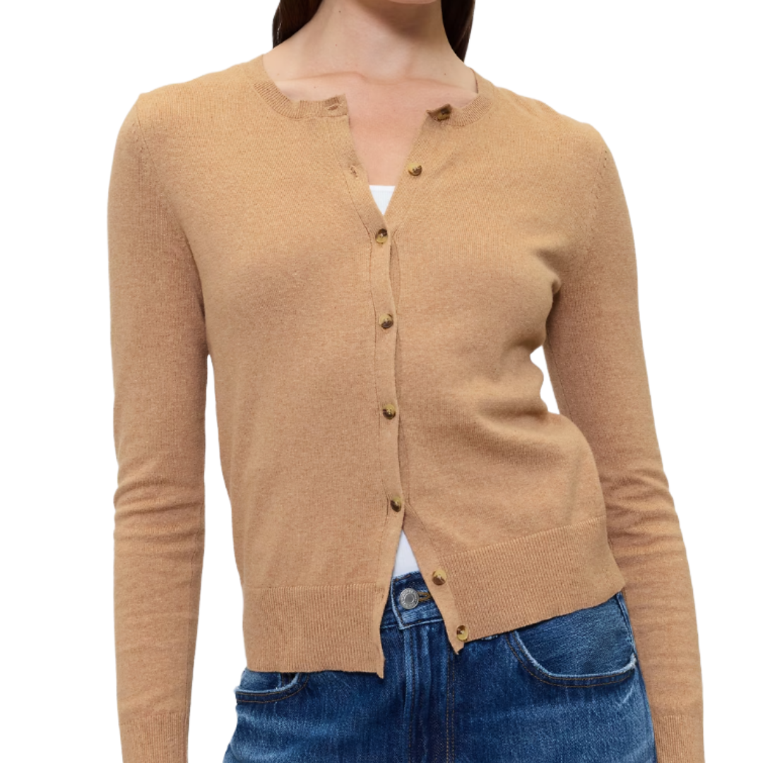 A tan, long-sleeve button-up cardigan is paired with blue jeans.