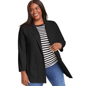 A woman is wearing a black open-front jacket with a striped black and white shirt underneath, paired with blue jeans.