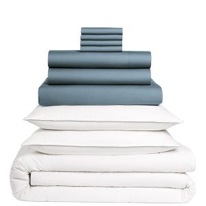 A stacked set of bedding items, including dark-colored sheets, pillowcases, and white pillows with a comforter.