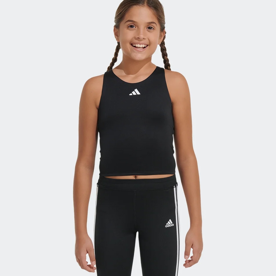 A young girl wearing a black sleeveless top and black athletic leggings with white stripes on the sides.