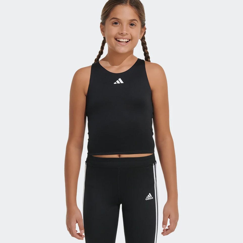A young girl wearing a black sleeveless top and black athletic leggings with white stripes on the sides.