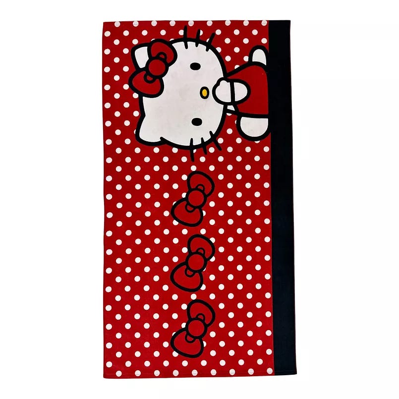 A red beach towel featuring a character design with a white face, red bow, and white polka dots, measuring 58 x 28 inches.