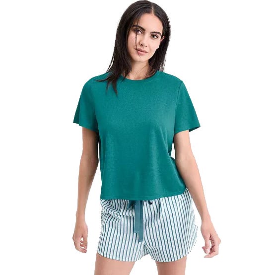 A woman is wearing a teal short-sleeve top paired with striped shorts featuring a drawstring waist.