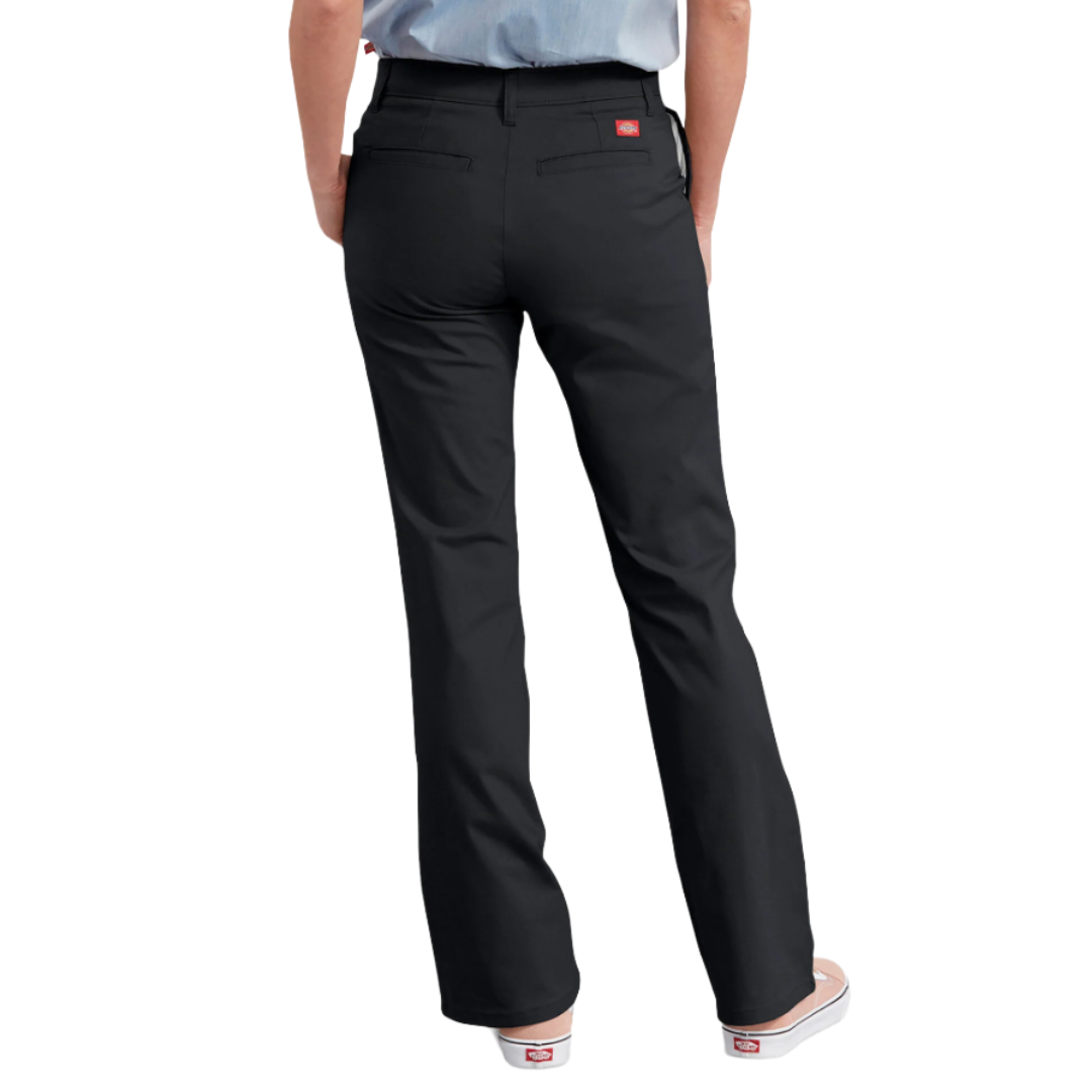 A person wearing black straight-leg pants with back pockets and a small logo label, paired with a light blue shirt and white slip-on shoes.