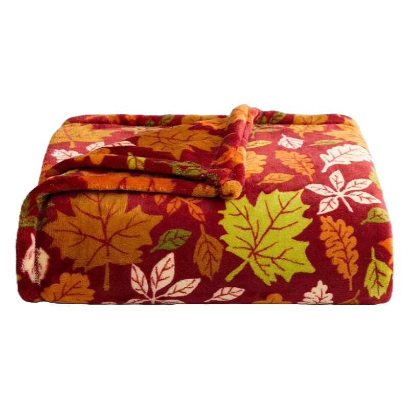 A folded fleece blanket with a pattern of colorful autumn leaves in shades of red, orange, green, and white.