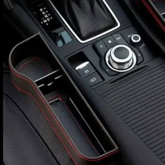 Car interior console featuring a gear shift, electronic parking brake, and control knobs.