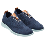 Navy blue knitted oxford shoes with light blue soles and tan leather accents on the tongue and heel tab.