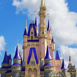 A castle with blue and gold spires against a blue sky with clouds.