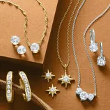 The image features a collection of gold and silver jewelry, including necklaces, earrings, and star-shaped pendants adorned with sparkling gemstones.