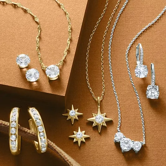 The image features a collection of gold and silver jewelry, including necklaces, earrings, and star-shaped pendants adorned with sparkling gemstones.