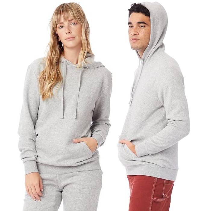 Two models are wearing light gray hoodies with front pockets, one paired with matching sweatpants, and the other with red pants.