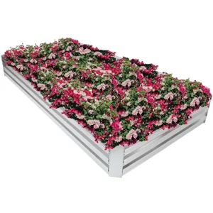 A raised garden bed filled with lush pink and red flowering plants, framed in a white, slatted design.