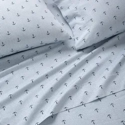 Bedding set with a nautical theme featuring blue and white stripes and small anchor designs.