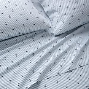 Bedding set with a nautical theme featuring blue and white stripes and small anchor designs.