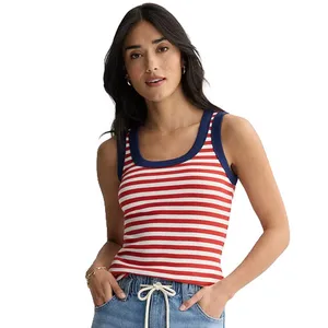 A woman wears a sleeveless red and white striped tank top with navy trim, paired with light blue drawstring pants.