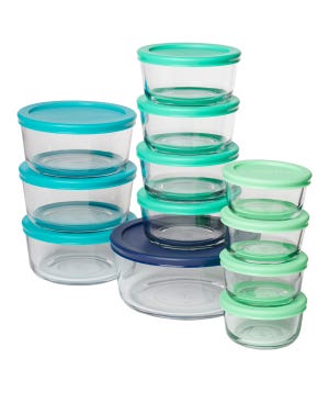 A set of clear glass food storage containers with colorful plastic lids in blue, teal, and green shades, in various sizes, stacked together.