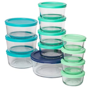 A set of clear glass food storage containers with colorful plastic lids in blue, teal, and green shades, in various sizes, stacked together.