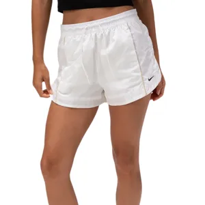 A person is wearing white Nike shorts with a small logo and matching Nike sneakers. The look is completed with a black top and white socks.