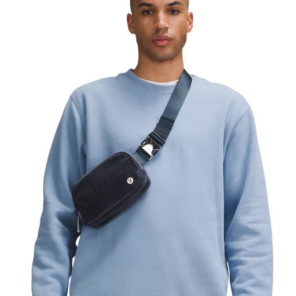 A unisex belt bag made from corduroy fabric, worn crossbody in the image. The bag features a sturdy adjustable strap with a buckle and a small lululemon logo on the front.