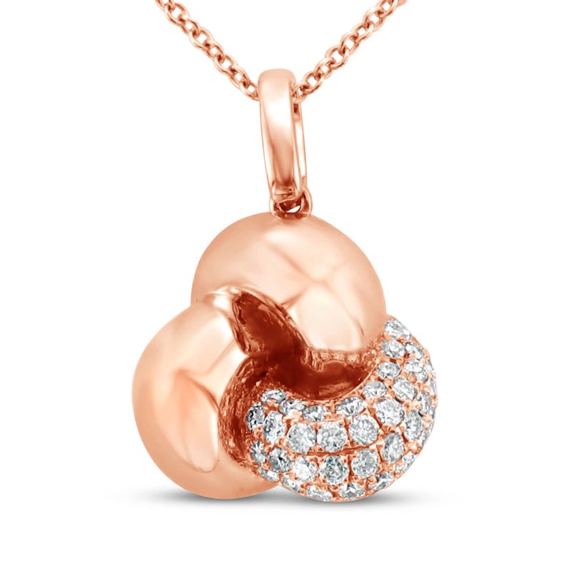 A rose gold pendant necklace featuring an abstract knot design with one section adorned with sparkling gemstones.