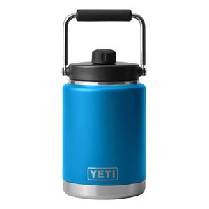 A blue YETI Rambler jug with a stainless steel base, black lid, and a sturdy handle.
