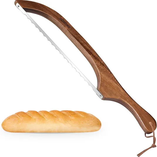 A wooden-handled serrated bread knife with a curved blade, designed for slicing bread, is shown alongside a loaf of bread.