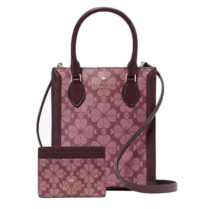 A small Kate Spade tote and matching card holder feature a pink floral pattern with burgundy leather details. The tote has top handles and a crossbody strap, and the card holder matches the same design and colors.