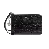 A black Coach wristlet with an embossed signature pattern, featuring a detachable strap and a rainbow-striped heart charm.