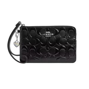A black Coach wristlet with an embossed signature pattern, featuring a detachable strap and a rainbow-striped heart charm.